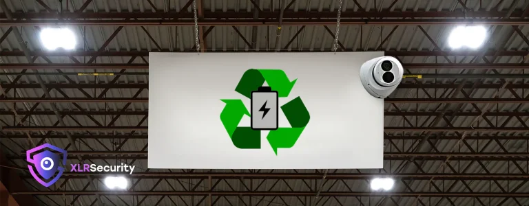 A sign hanging in a warehouse with a recycling logo and a security camera