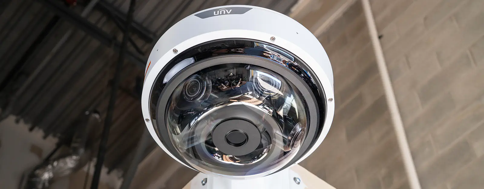 A large security camera mounted to a corner bracket with four lenses internally